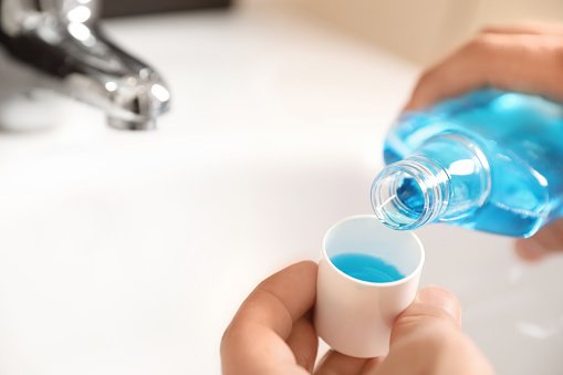Man pouring mouthwash from bottle into cap in bathroom, closeup. Teeth care Image source: Pixabay